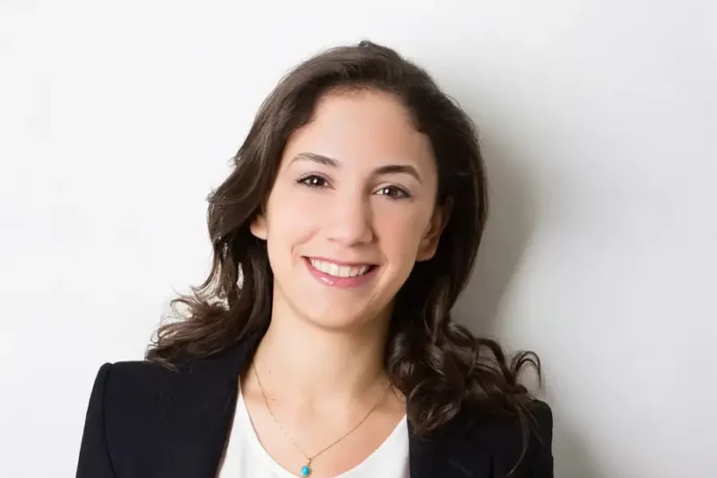 Portrait of Mirna Monla, with a light neutral background