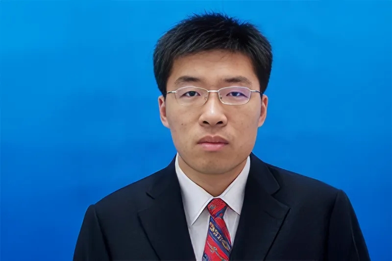 Studioportrait of Dongfeng Zhao, with a light blue neutral background and soft lighting