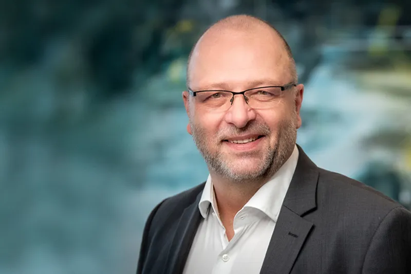 Portrait of Dr. Stefan Leupertz, blurred background details.
