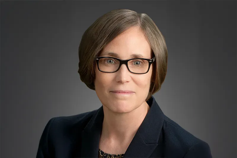 Studioportrait of Prof. Janet Walker, with a dark neutral background